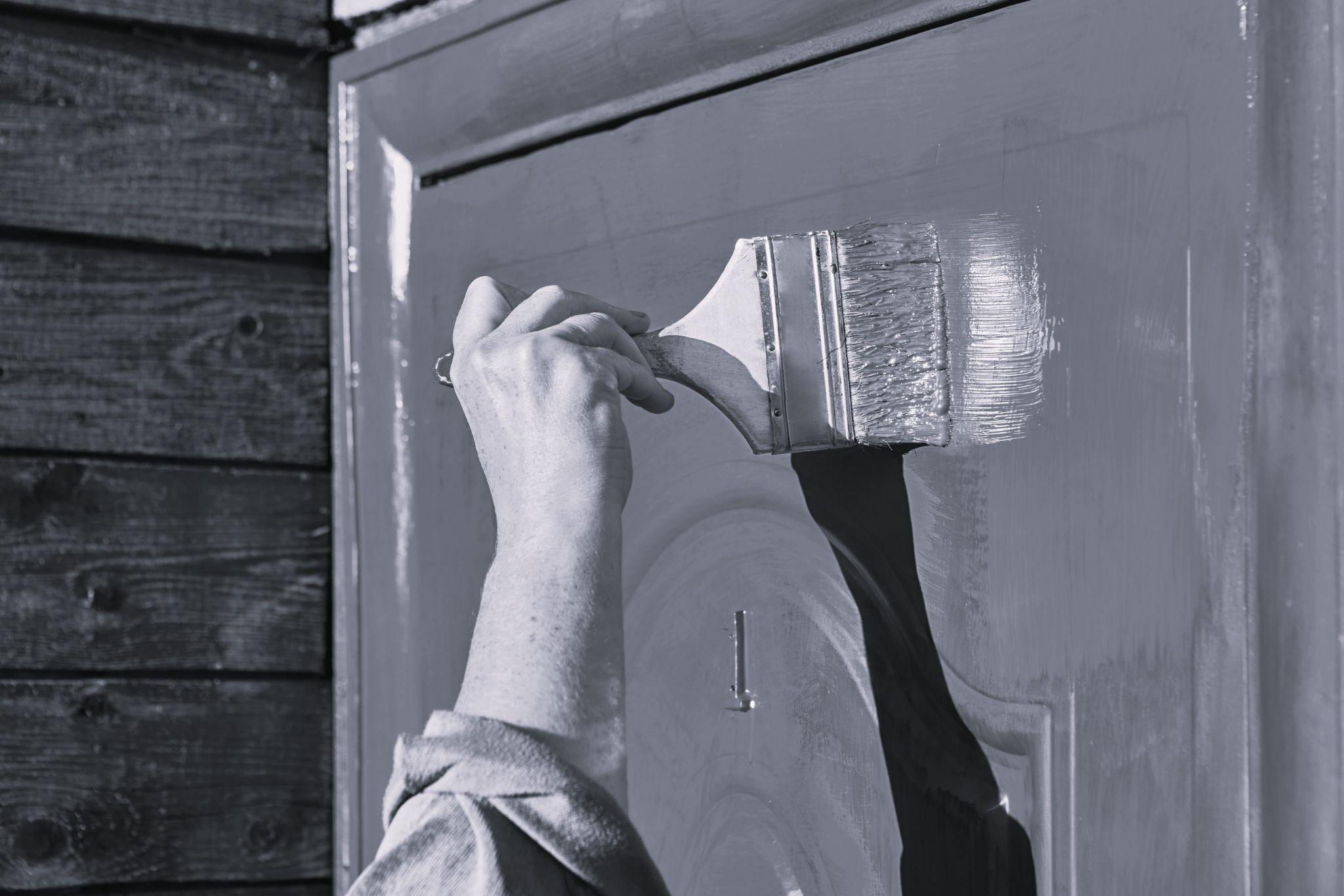 Landlord painting front door to improve curb appeal