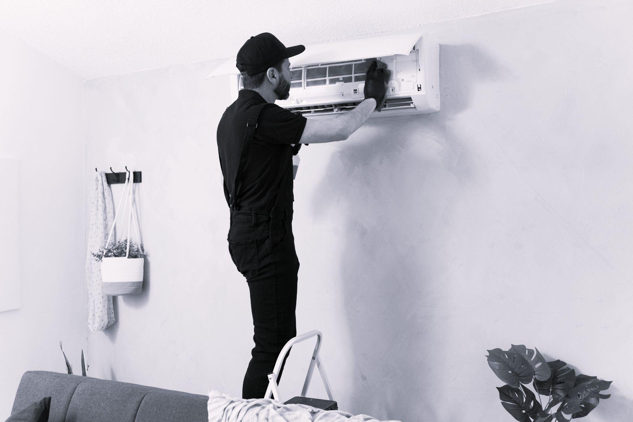 Repairman working on an air conditioning unit in a rental property