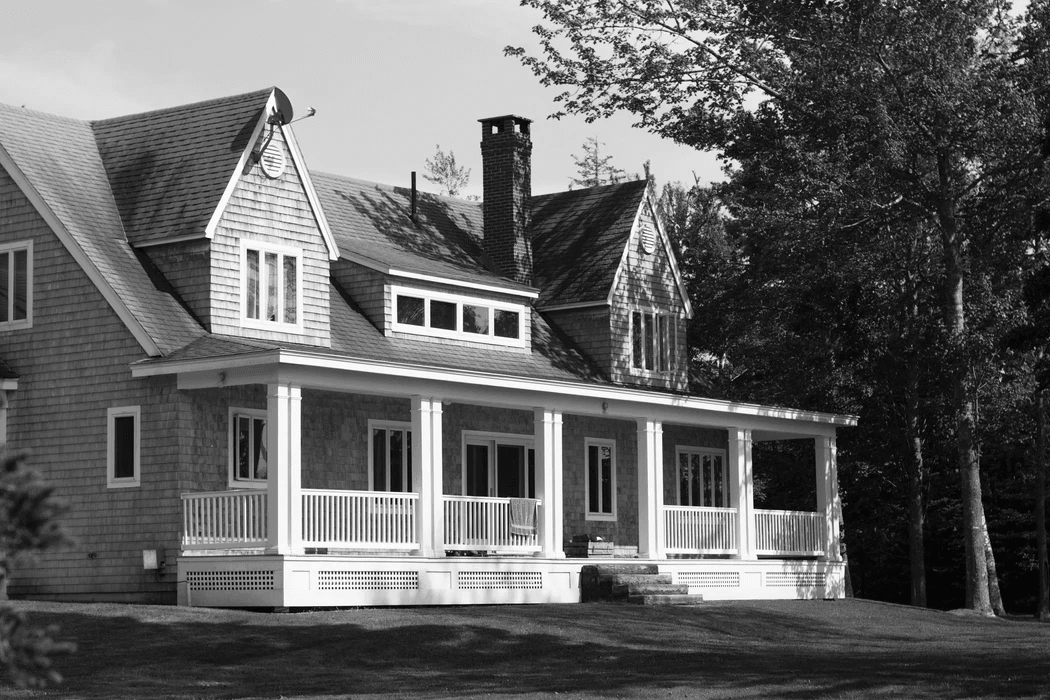 white and brown wooden house near green trees during daytime
