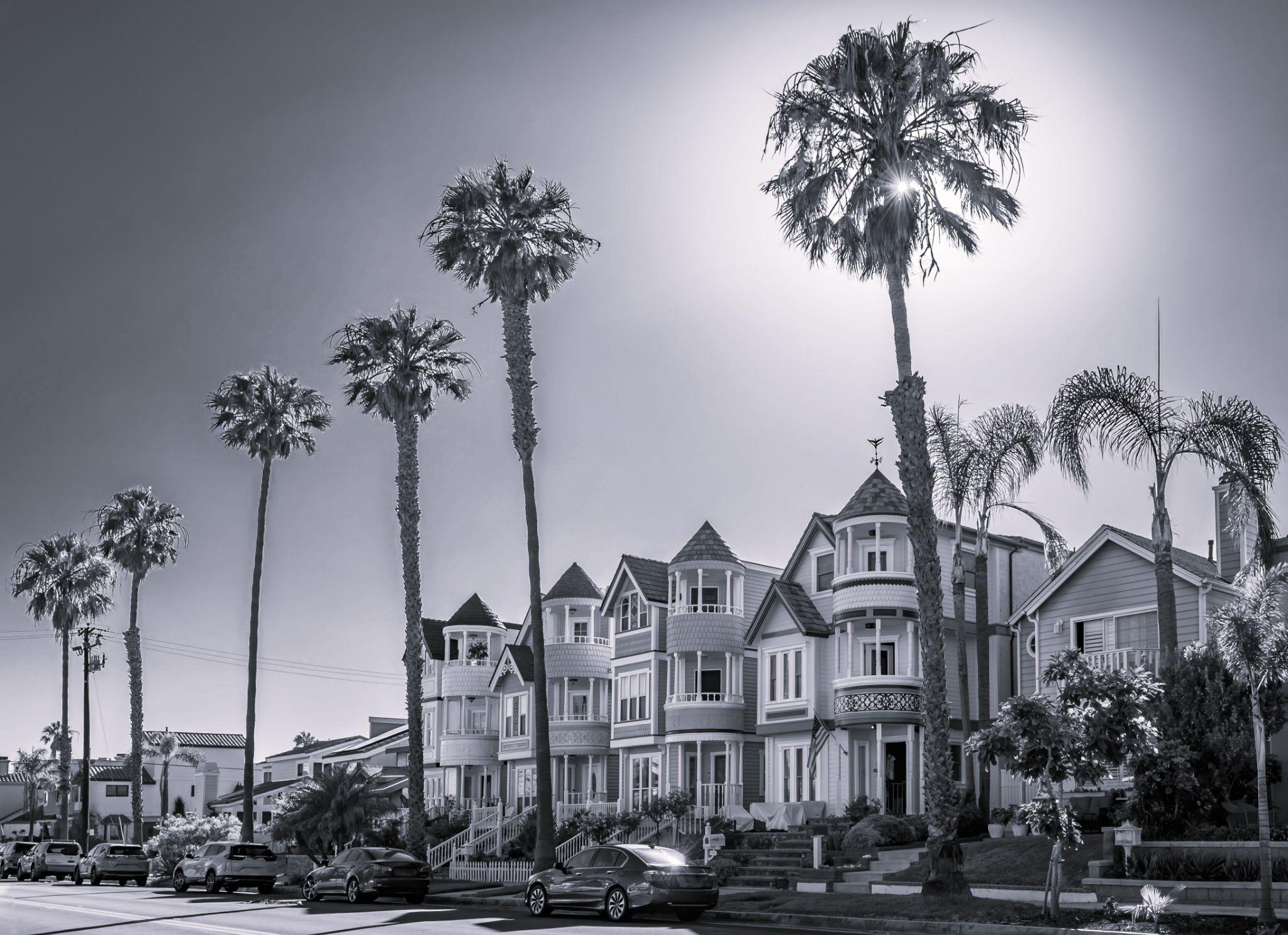Ornate old Victorian houses on a street lined with palm trees in Huntington Beach Ornate old Victorian houses on a street lined with palm trees in Huntington Beach