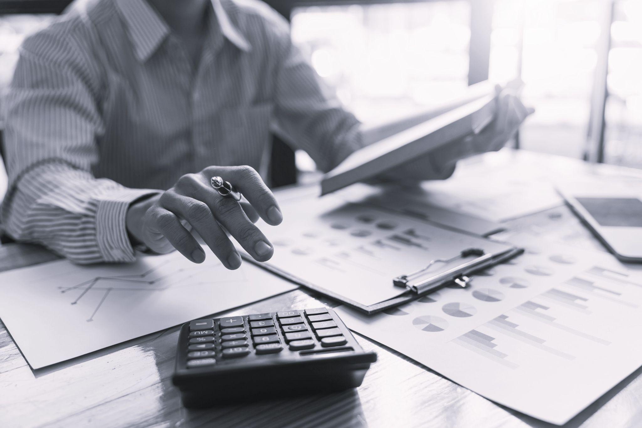businessman hand working with finances about cost and calculator