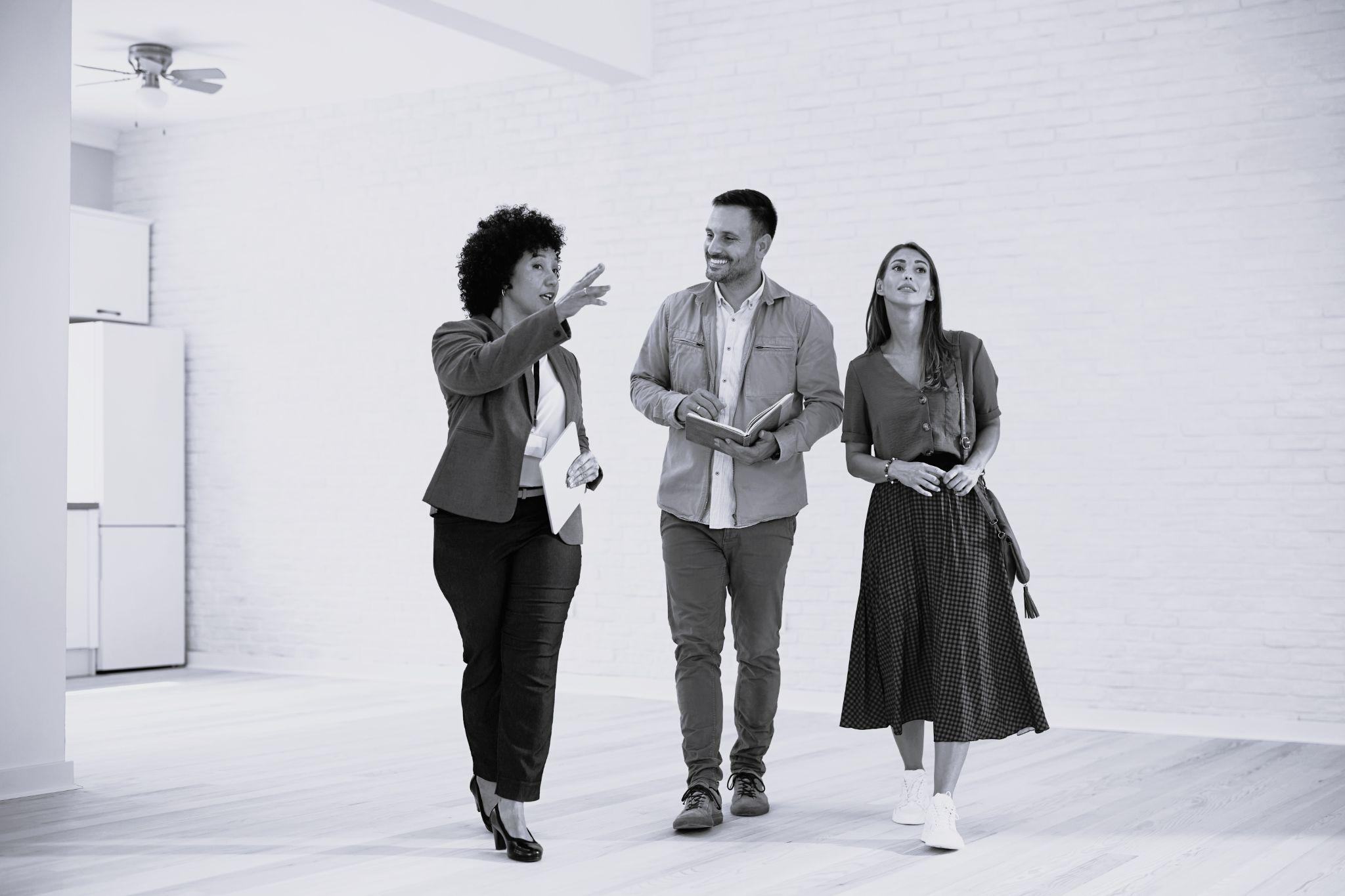 Young couple communicating with their real estate agent while buying new house